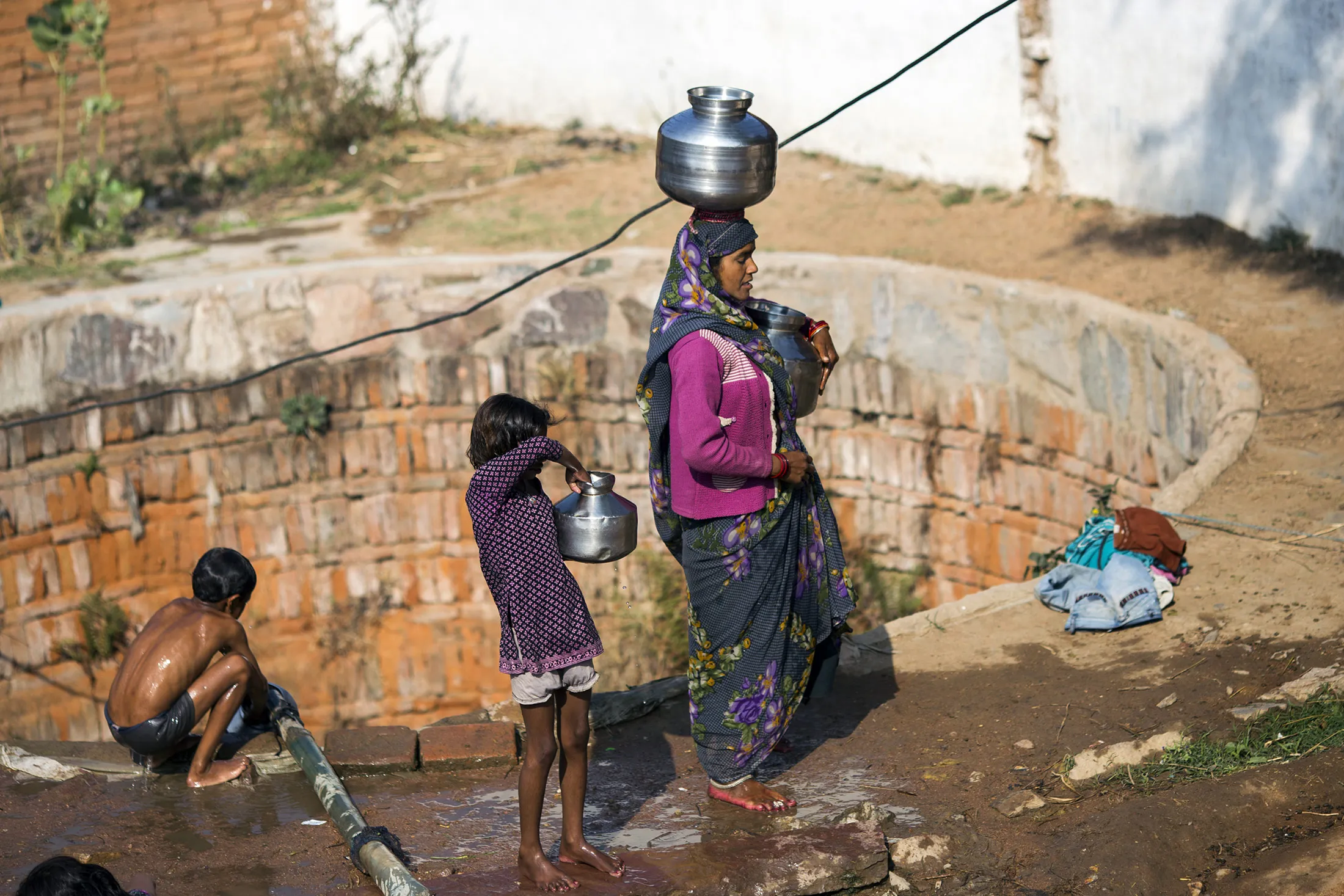 A woman carries a pot filled with water on her head in the village of Shyampura in Tikamgarh, Madhya Pradesh, India, on Feb. 9.
