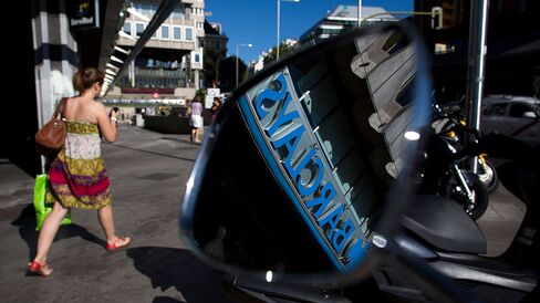 A Barclays logo is seen in the wing mirror of a scooter parked outside a Barclays Plc bank branch in Madrid.
