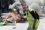 A protester wearing a mask of French President Emmanuel Macron.