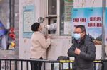 A medical worker takes a swab sample from a resident in Harbin, Heilongjiang province, China, on Nov. 3.