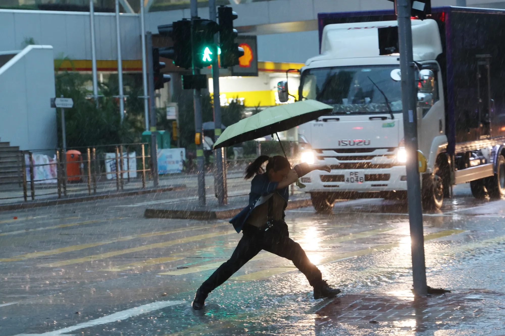 A pedestrian crosses a road during heavy rainfall in Hong Kong on Aug. 5.