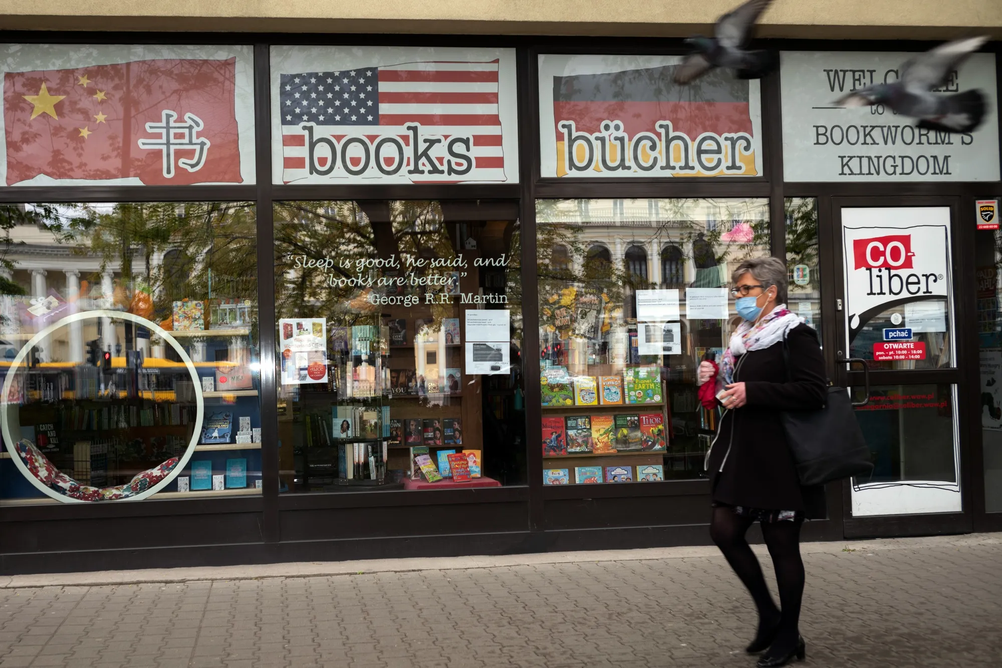 A pedestrian wearing a protective face mask passes a closed book store in Warsaw, on April 29.