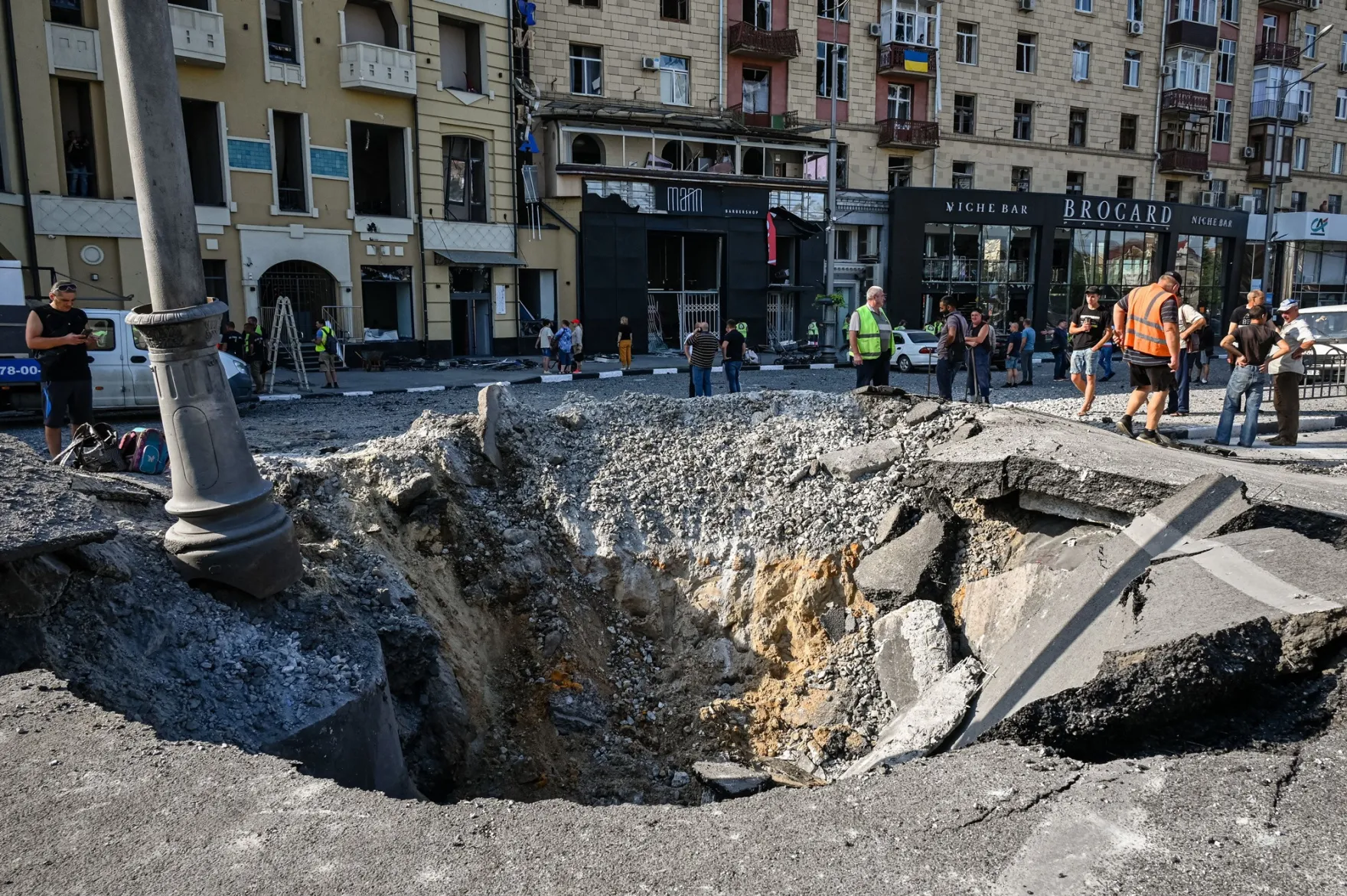 Municipal service workers monitor a&nbsp; crater following an overnight missile strike in Kharkiv, Ukraine.