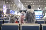 A family wearing masks and make-shift protection gear wait for their train at the Hongqiao High-speed Railway Station in Shanghai, China.