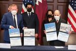 Stan Deal, president and chief executive officer of commercial airplanes with the Boeing Co., left, and Akbar Al Baker, chief executive officer of Qatar Airways QCSC, right, hold up documents&nbsp;during a signing ceremony in Washington, on Jan. 31.