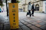 Pedestrians walk past a&nbsp;social distancing sign in Glasgow&nbsp;on Sept.&nbsp;14.