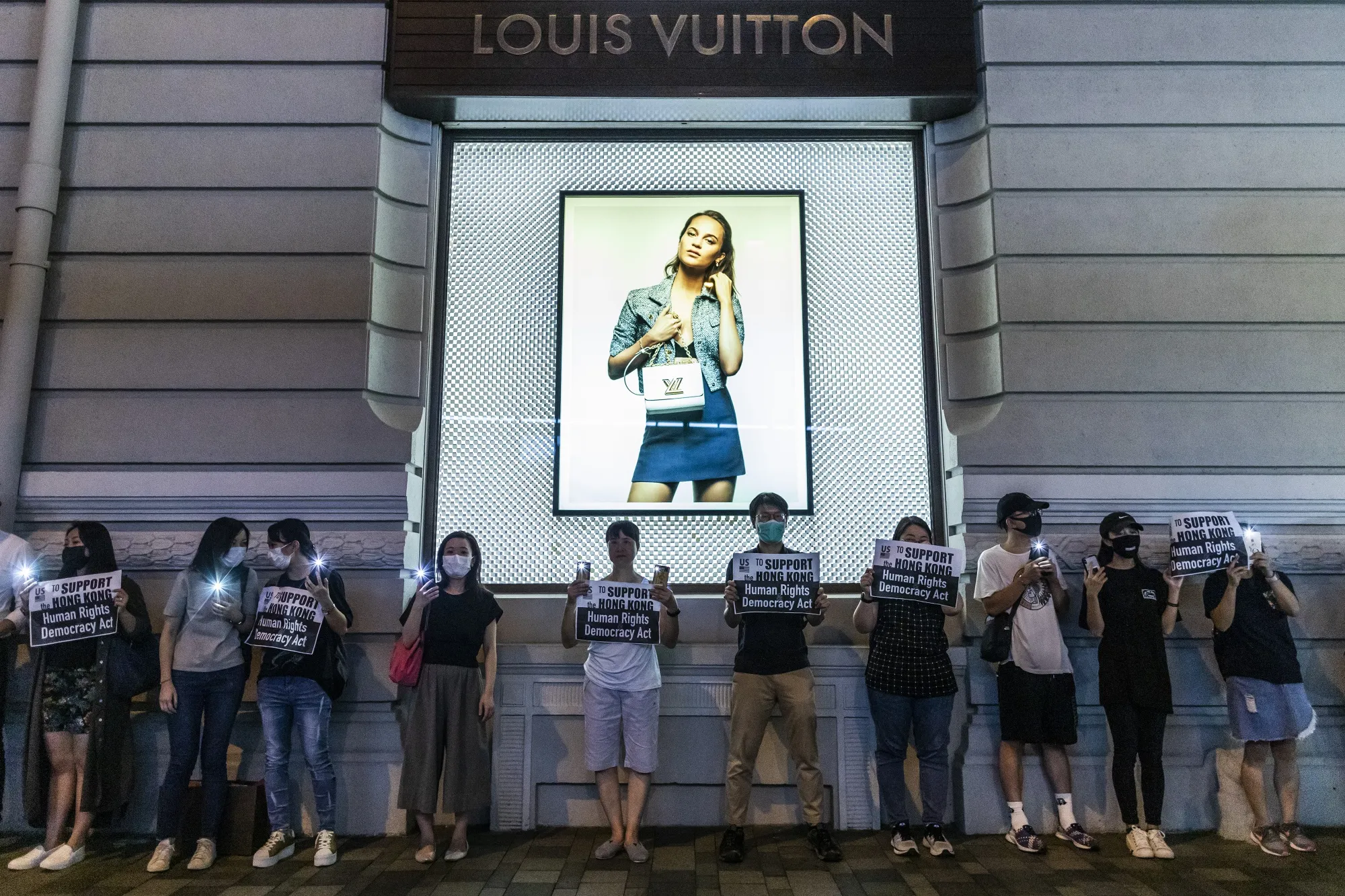 Demonstrators form a human chain in front of a Louis Vuitton in Tsim Sha Tsui on Aug. 23.