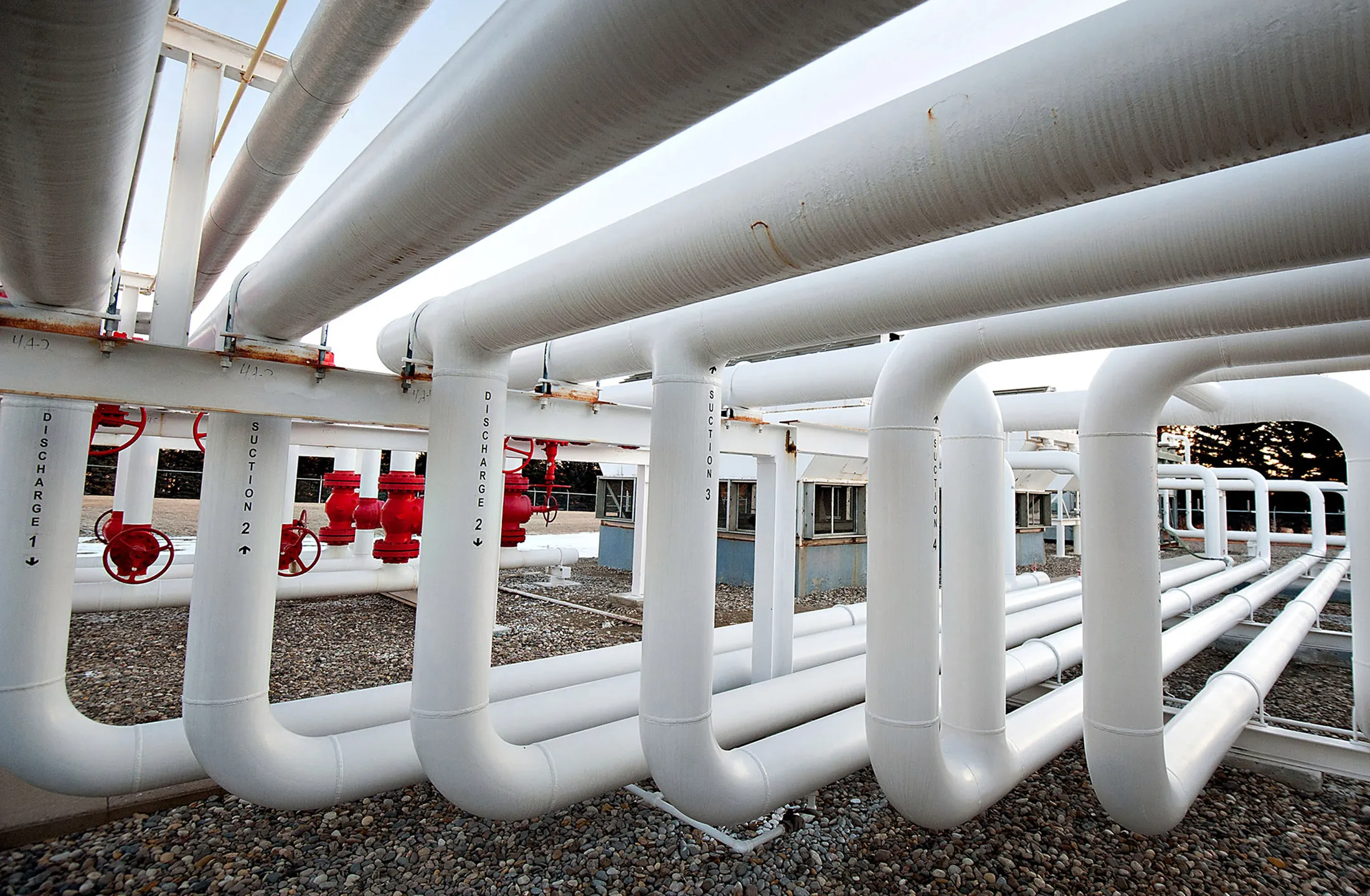 A series of pipes direct natural gas at a compression station.