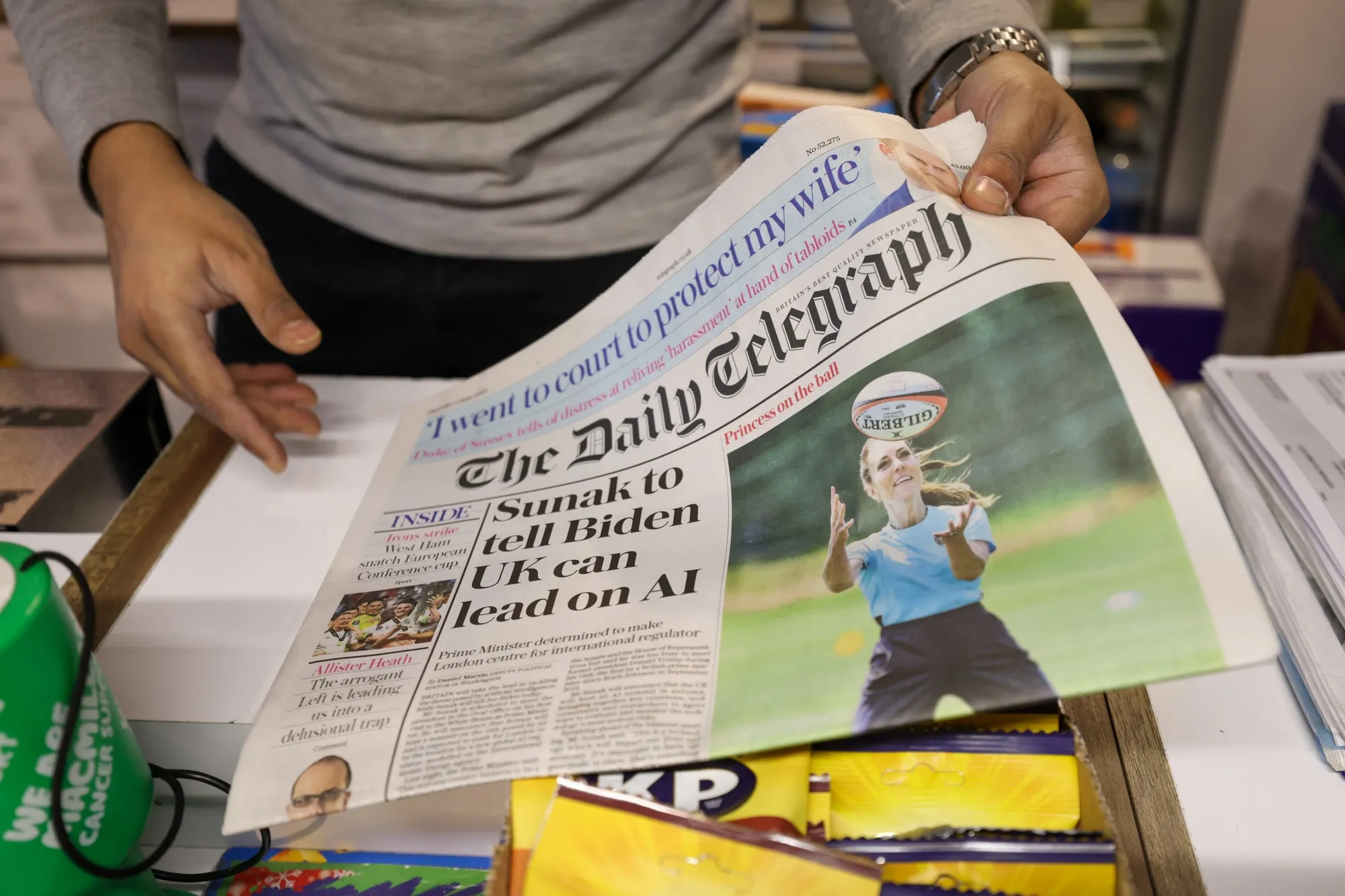 A customer buys a copy of The Daily Telegraph newspaper in London in June.
