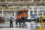 Employees move a truck with a crane at the Daimler India Commercial Vehicles plant in Chennai, India.
