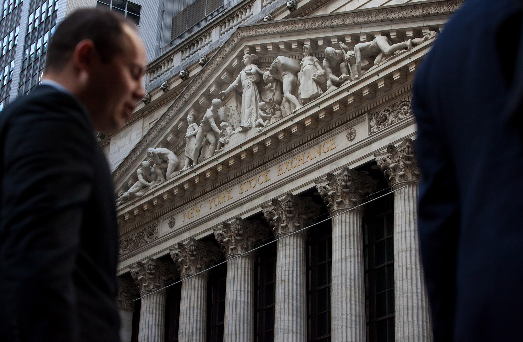 A pedestrian walks past the New York Stock Exchange (NYSE)
