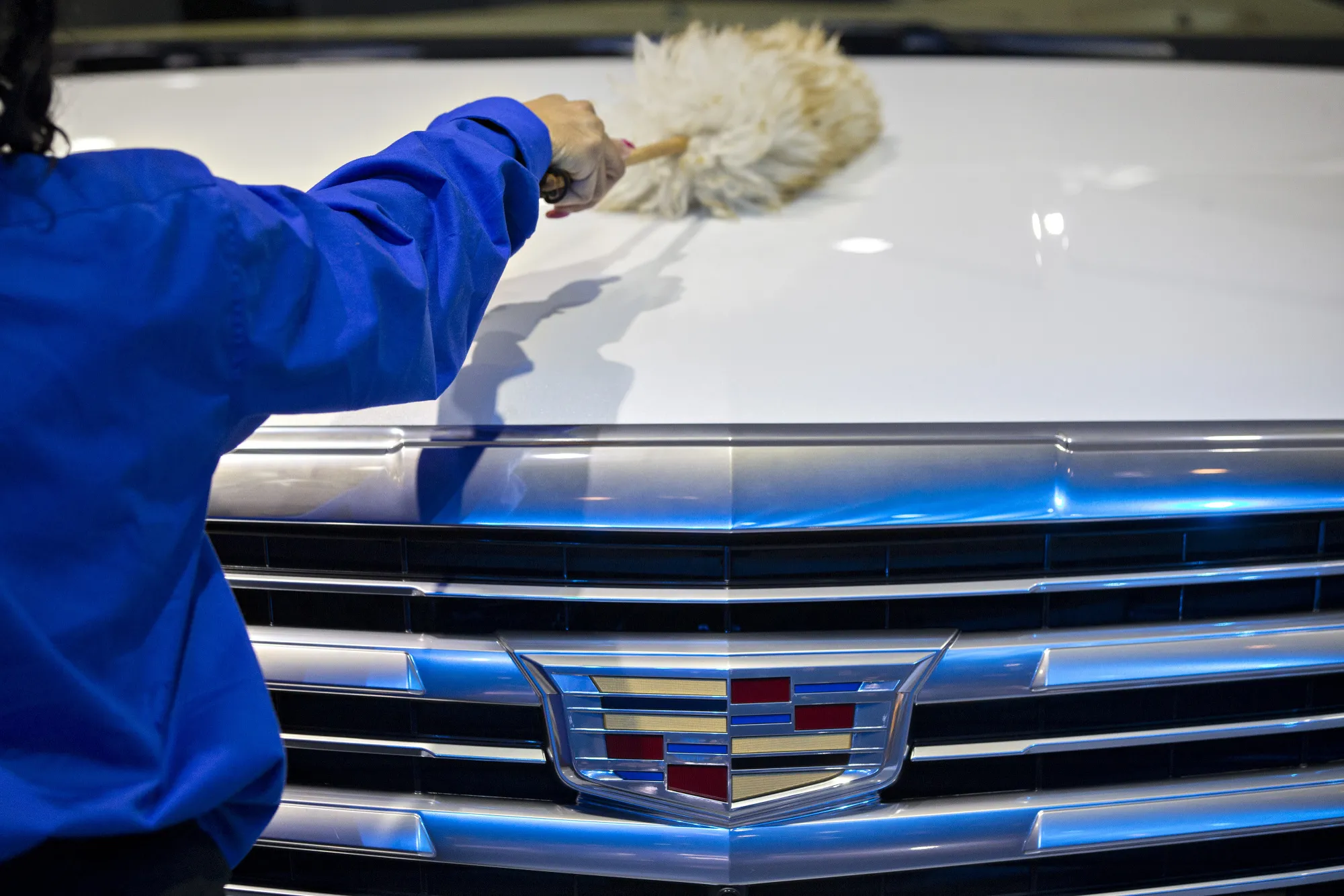 A worker cleans a A General Motors Co. (GM) Cadillac 2017 Escalade sports utility vehicle (SUV) during the 2017 North American International Auto Show (NAIAS) in Detroit, Michigan, U.S., on Tuesday, Jan. 10, 2017. Last January, the 2016 NAIAS featured 61 vehicle introductions, a majority of which were worldwide debuts, and was attended by over 5,000 journalists from 60 countries.