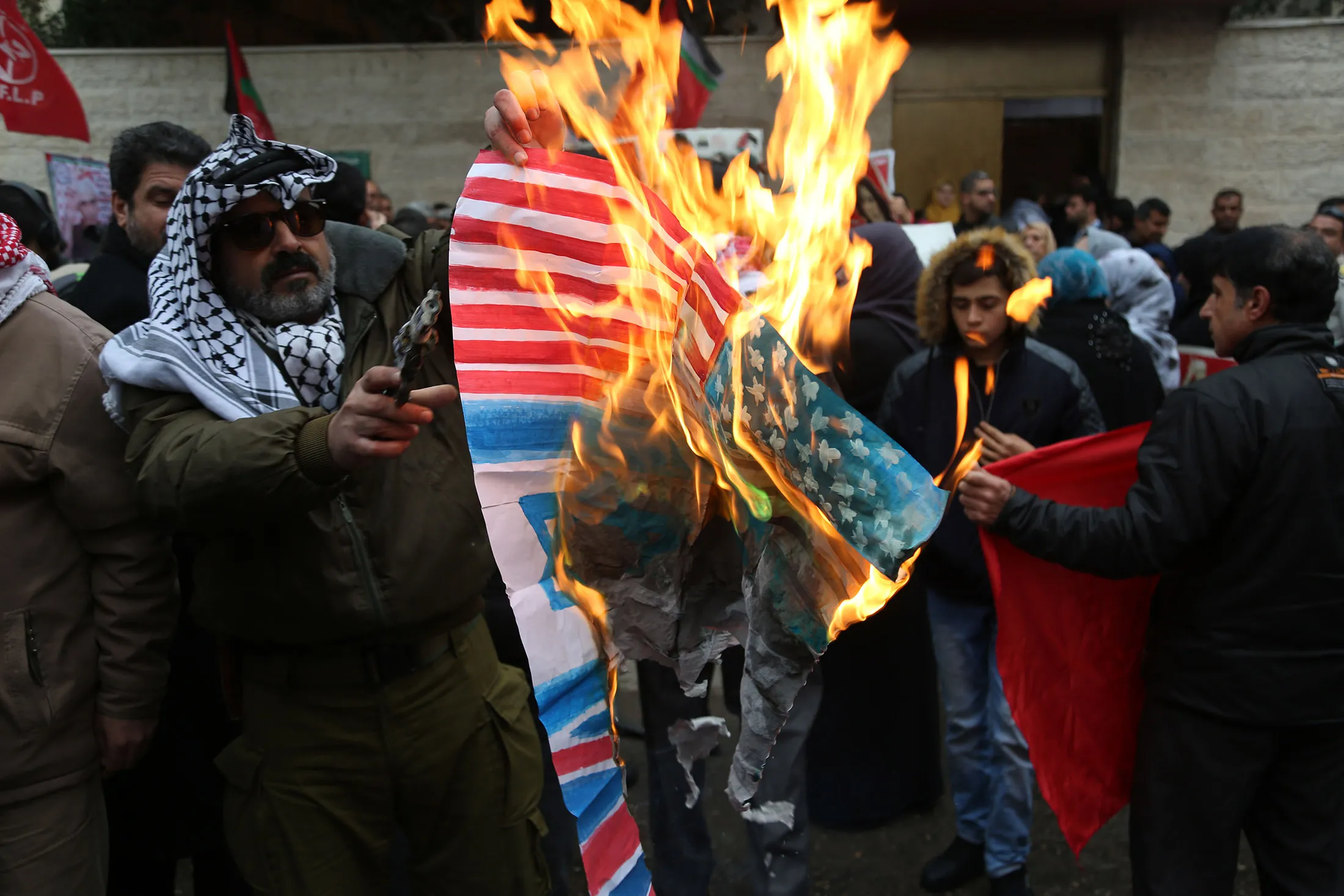 Palestinians burn posters depicting U.S. President Donald Trump and a U.S. flag and Israeli flag during a protest against Trump's decision to recognize Jerusalem as the capital of Israel, in Gaza City on Jan.1, 2018.&nbsp;
