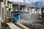 A worker prepares siding to install on a single family home under construction in Lehi, Utah, U.S., on Friday, Jan. 7, 2022. 