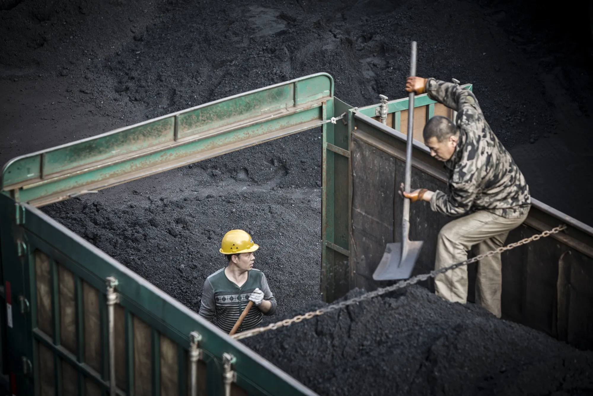 Employees unload coal from a truck at a coal mine and processing facility in Liulin, Shanxi province, China.