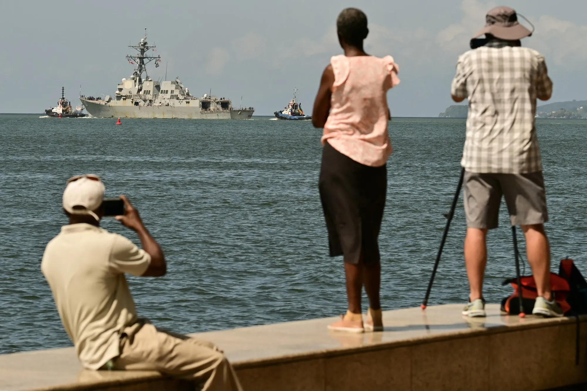 People watch and take pictures of a US Navy warship departing the Port of Port of Spain in&nbsp;Trinidad and Tobago.