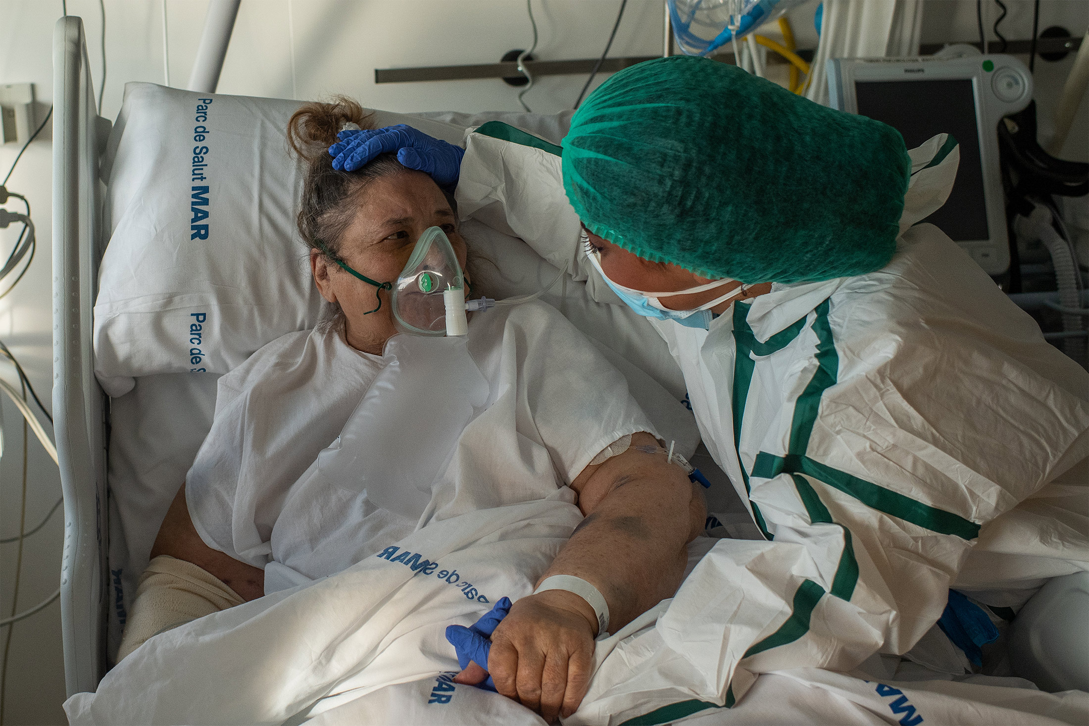 A Covid-19 patient is being comforted by a medical worker at a hospital in Barcelona, Spain, on December 25th.