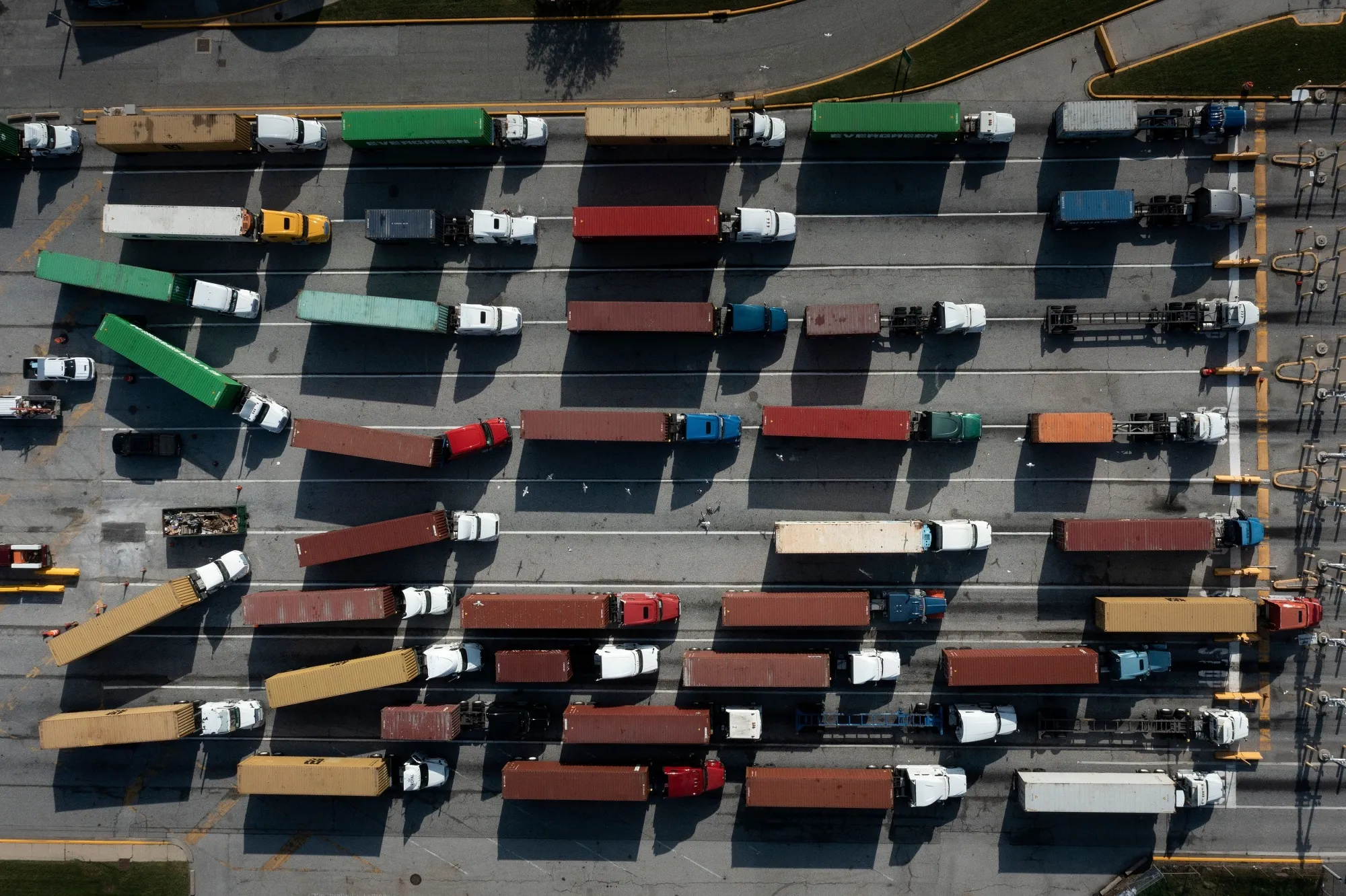 TOPSHOT - In this aerial image, Trucks transport cargo containers at the Port of Baltimore in Baltimore, Maryland, on October 14, 2021. - Closed factories, clogged ports, no truck drivers -- up and down the global supply chain there are problems, raising concerns that it could disrupt the global economic recovery. (Photo by Brendan Smialowski / AFP) (Photo by BRENDAN SMIALOWSKI/AFP via Getty Images)