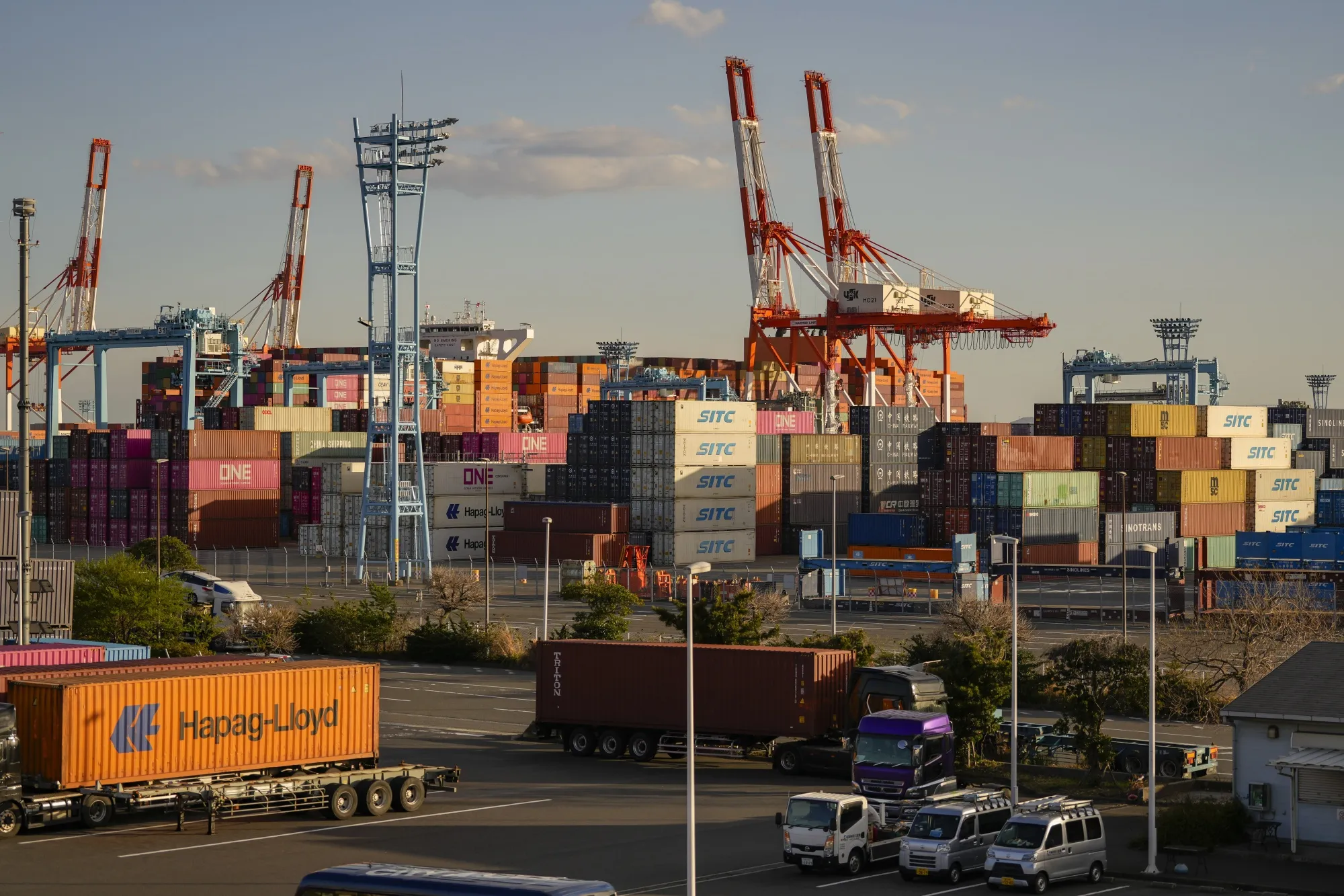 Containers next to gantry cranes at a shipping terminal in Yokohama, Japan, on Tuesday, April 15, 2025. Japan is scheduled to release trade figures on April 17.
