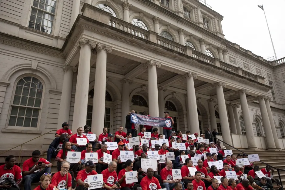 Ride-share drivers and supporters with the Independent Drivers Guild protest outside New York City Hall as they rally for wage enforcement and a drivers' bill of rights.