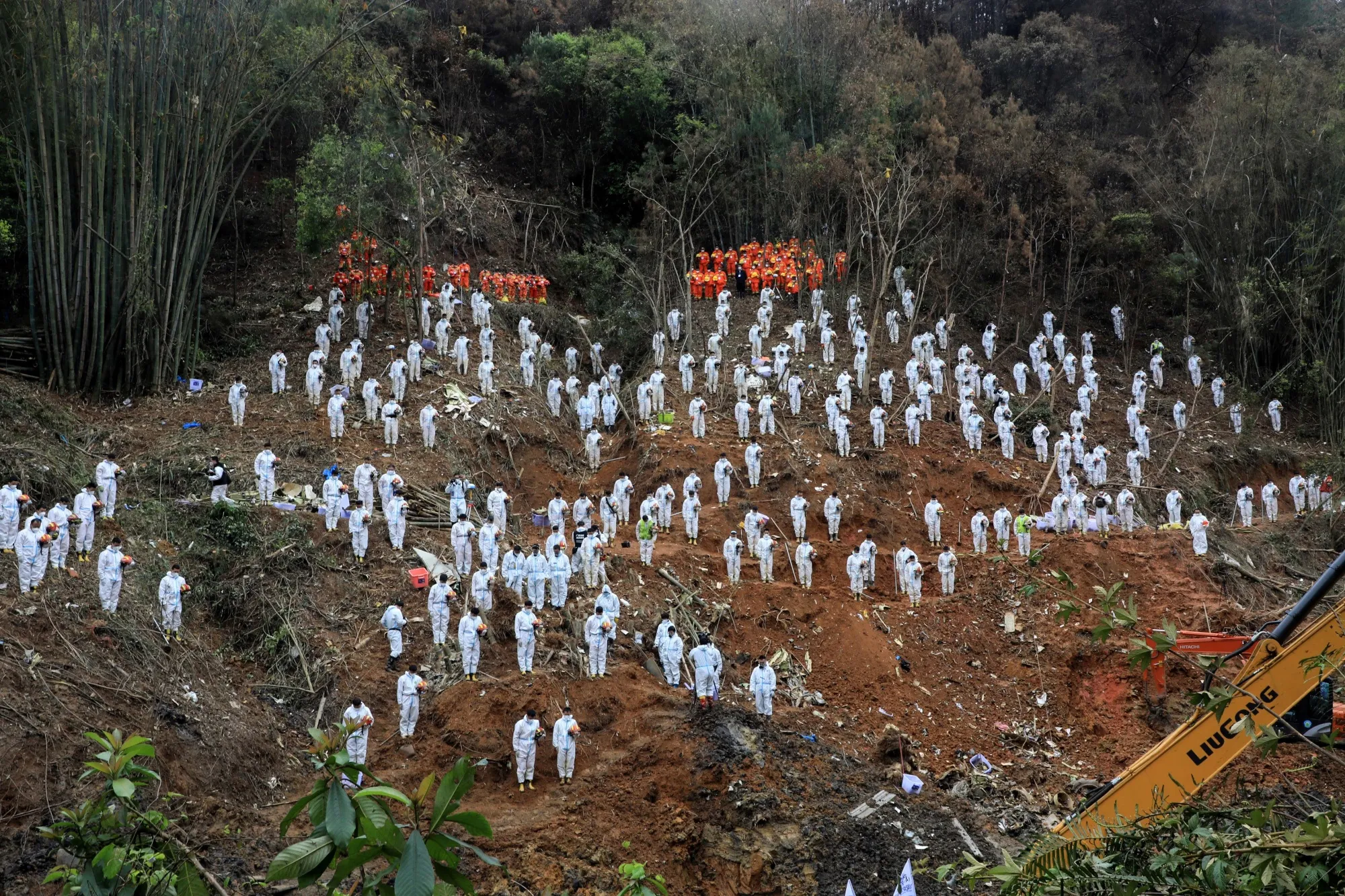 Rescuers stand in a silent tribute for victims at the site of the China Eastern Airlines plane crash in&nbsp;China's Guangxi region, on&nbsp;March 27.