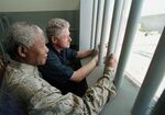 Nelson Mandela, left, and former US president Bill Clinton look to the outside from Mandela's Robben Island prison cell in Cape Town, South Africa, March 27, 1998.