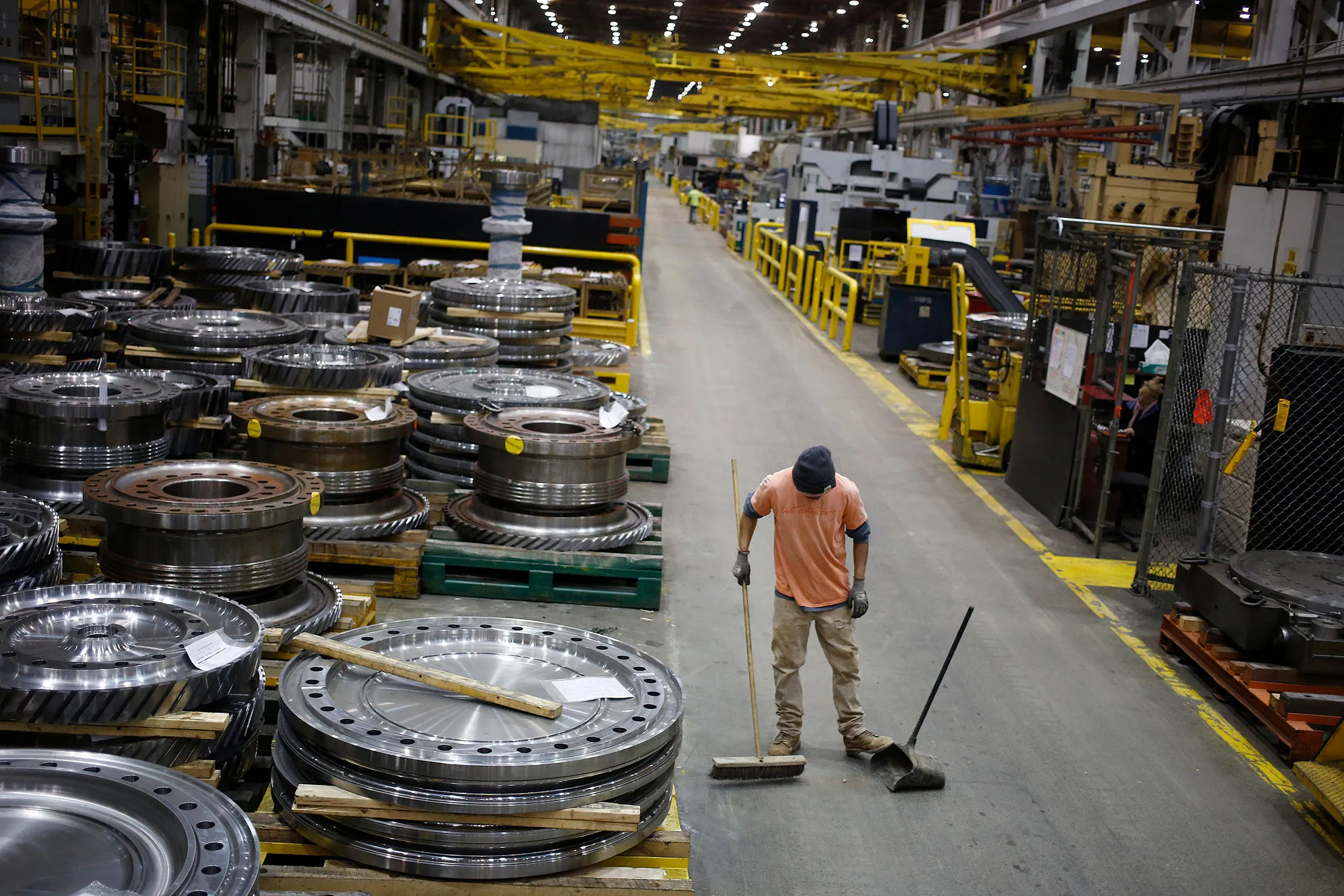 A worker sweeps the floor near gas turbine parts at the General Electric Co. (GE) energy plant in Greenville, South Carolina, U.S., on Tuesday, Jan. 10, 2017. General Electric Co. is scheduled to release earnings figures on January 20.
