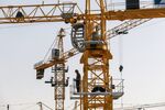 A worker stands on a crane at the Sunac Resort project construction site.