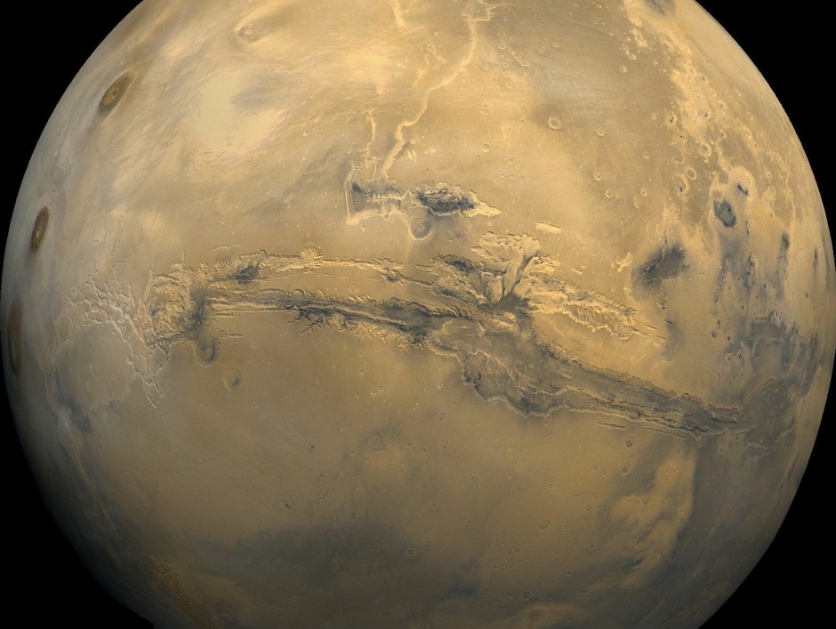 The largest canyon in the solar system, Valles Marineris, cuts across the face of Mars.