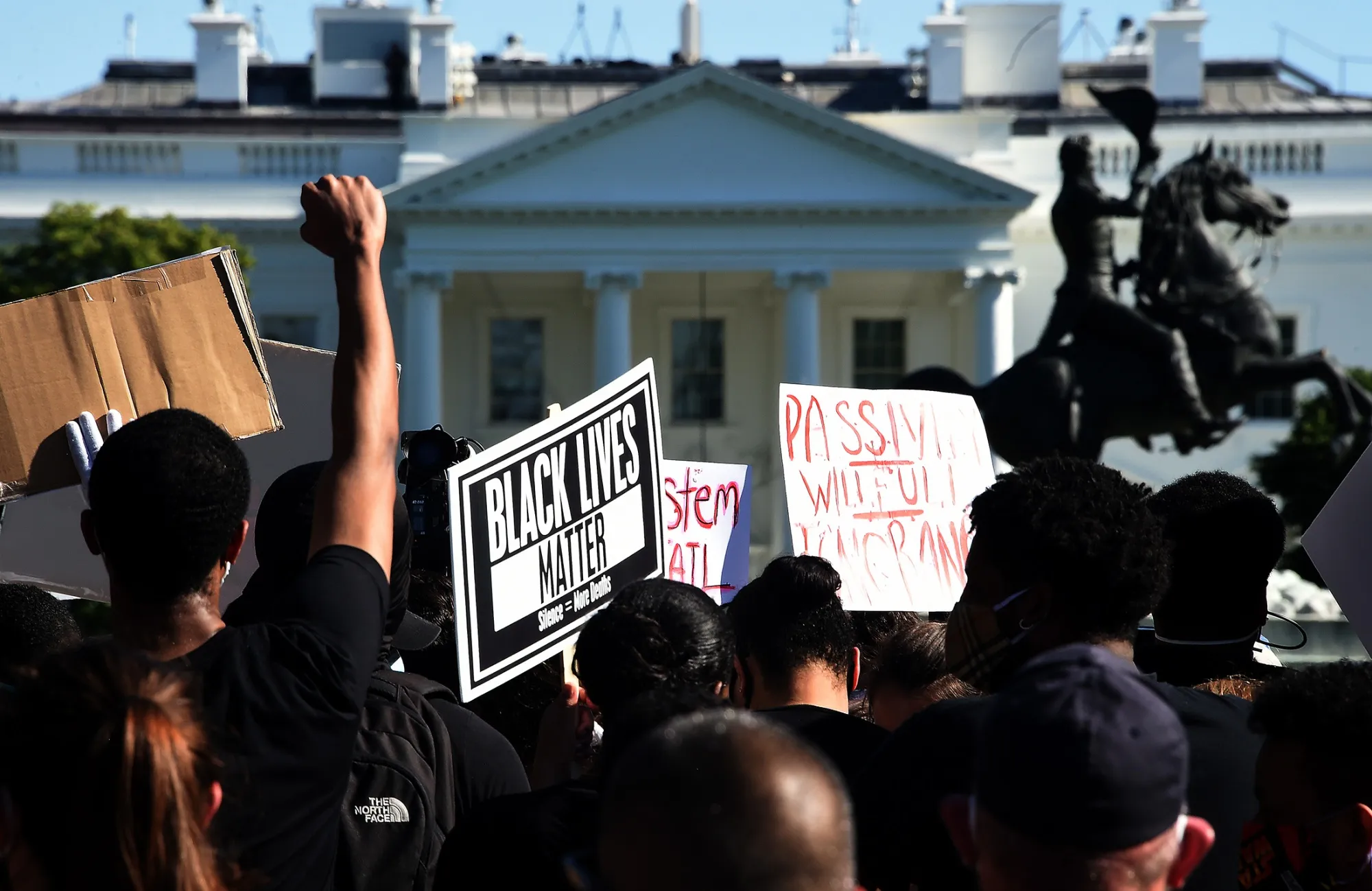 Demonstrators hold up placards near the White House&nbsp;in Washington on June 1.&nbsp;&nbsp;