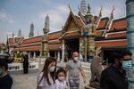 Tourists wearing face masks while visiting the Temple of the Emerald Buddha in Bangkok.&nbsp;