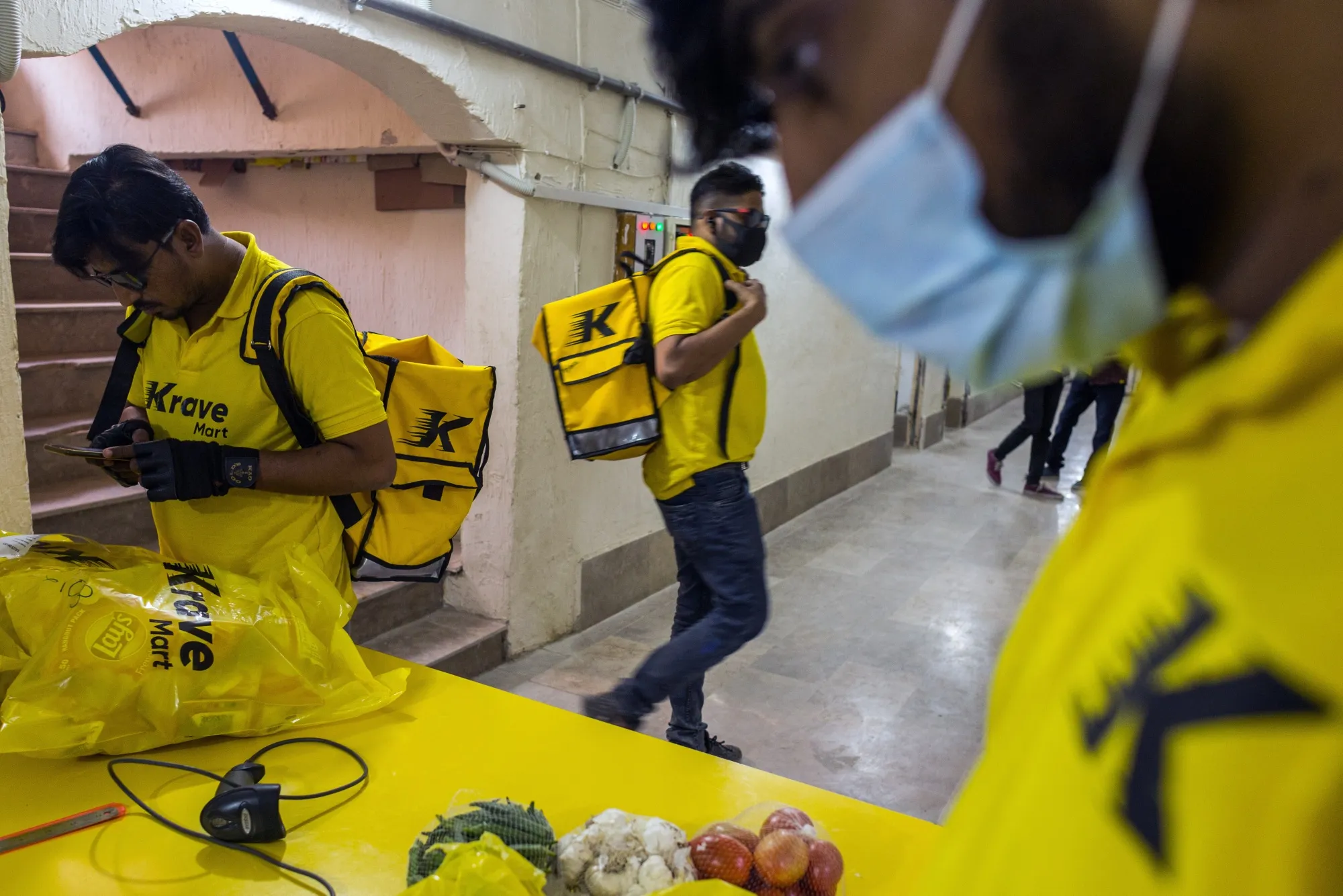 Krave Mart delivery riders check orders at one of the company’s locations in Karachi.