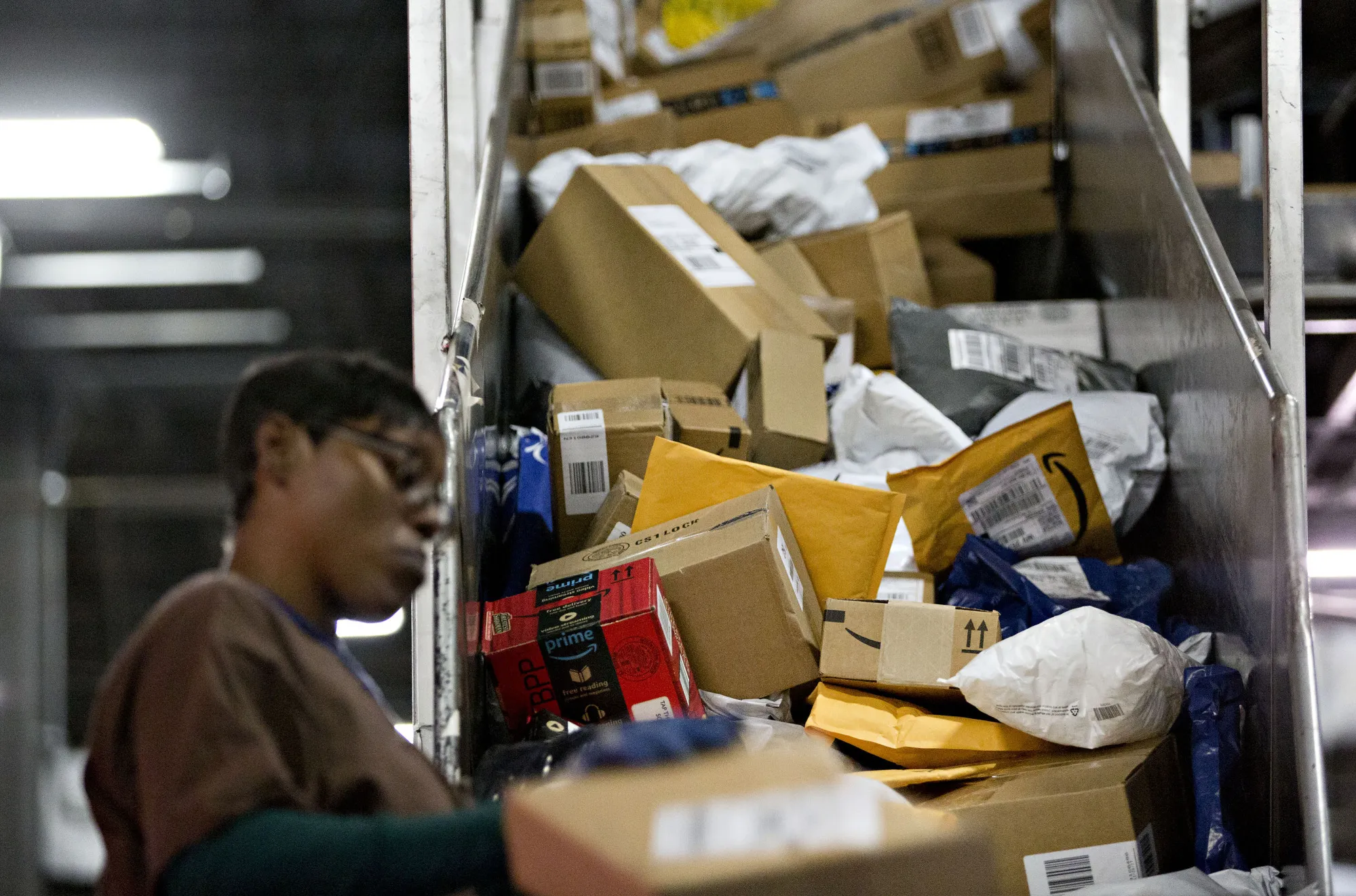 An employee sorts packages at a UPS sorting facility.