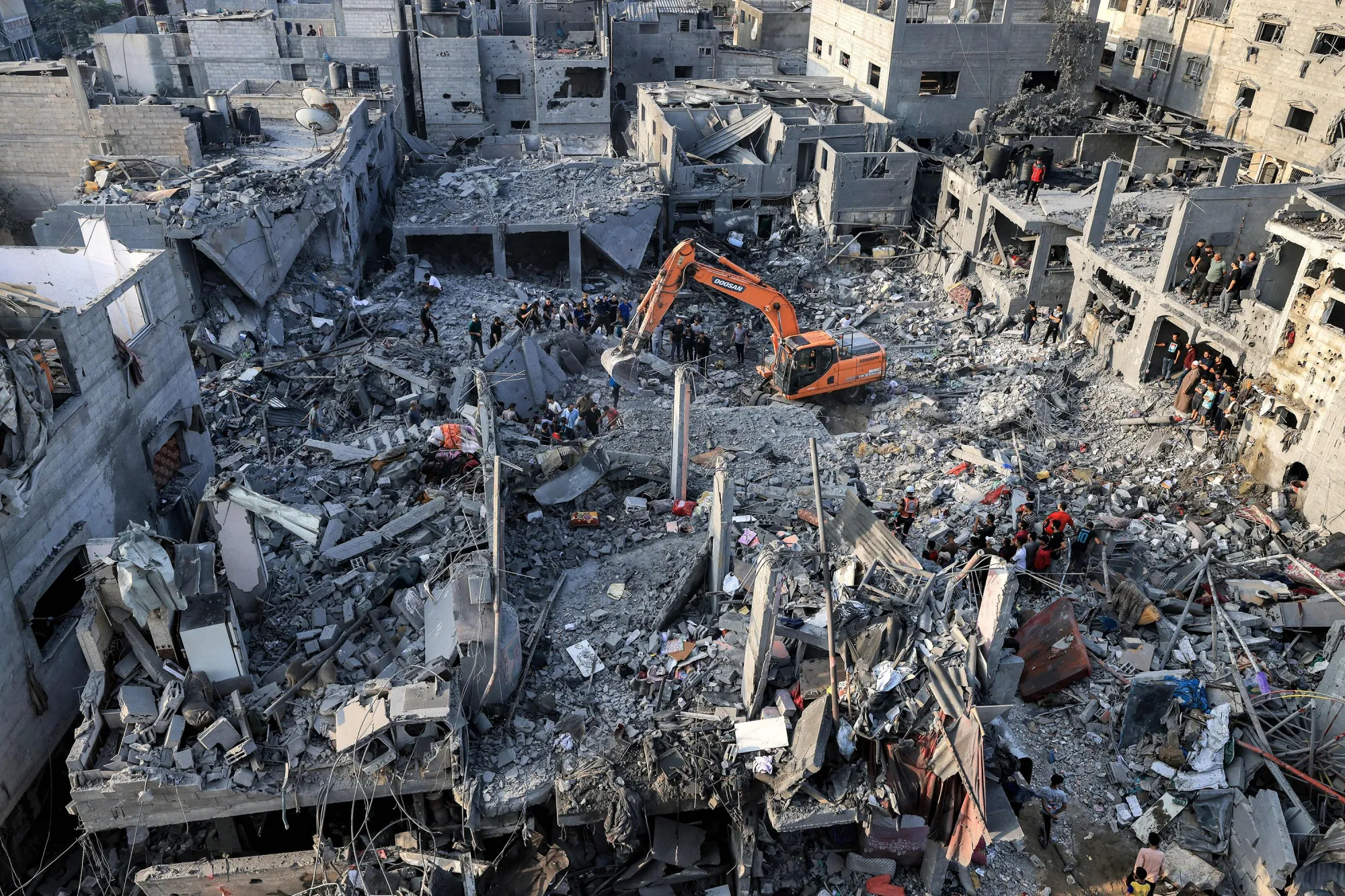 An excavator clears rubble as people search for survivors and bodies of victims through buildings&nbsp;following a strike in Khan Yunis in Gaza,on Oct. 25.