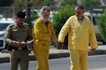 Volker Waldmann, right, and Jim Fitton, center, walk to a courtroom in Baghdad, Iraq, May 22. 