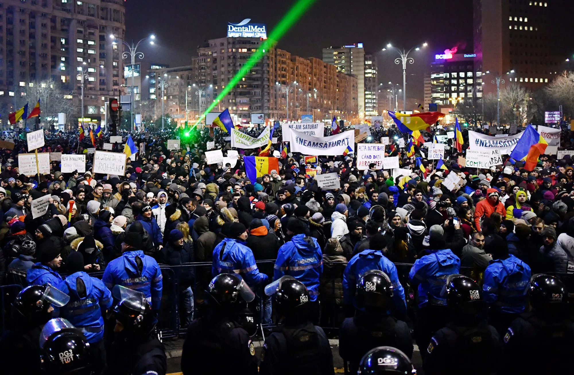 Riot police stand guard as demonstrators gather in front of the government headquarters in Bucharest, on Feb. 1.

