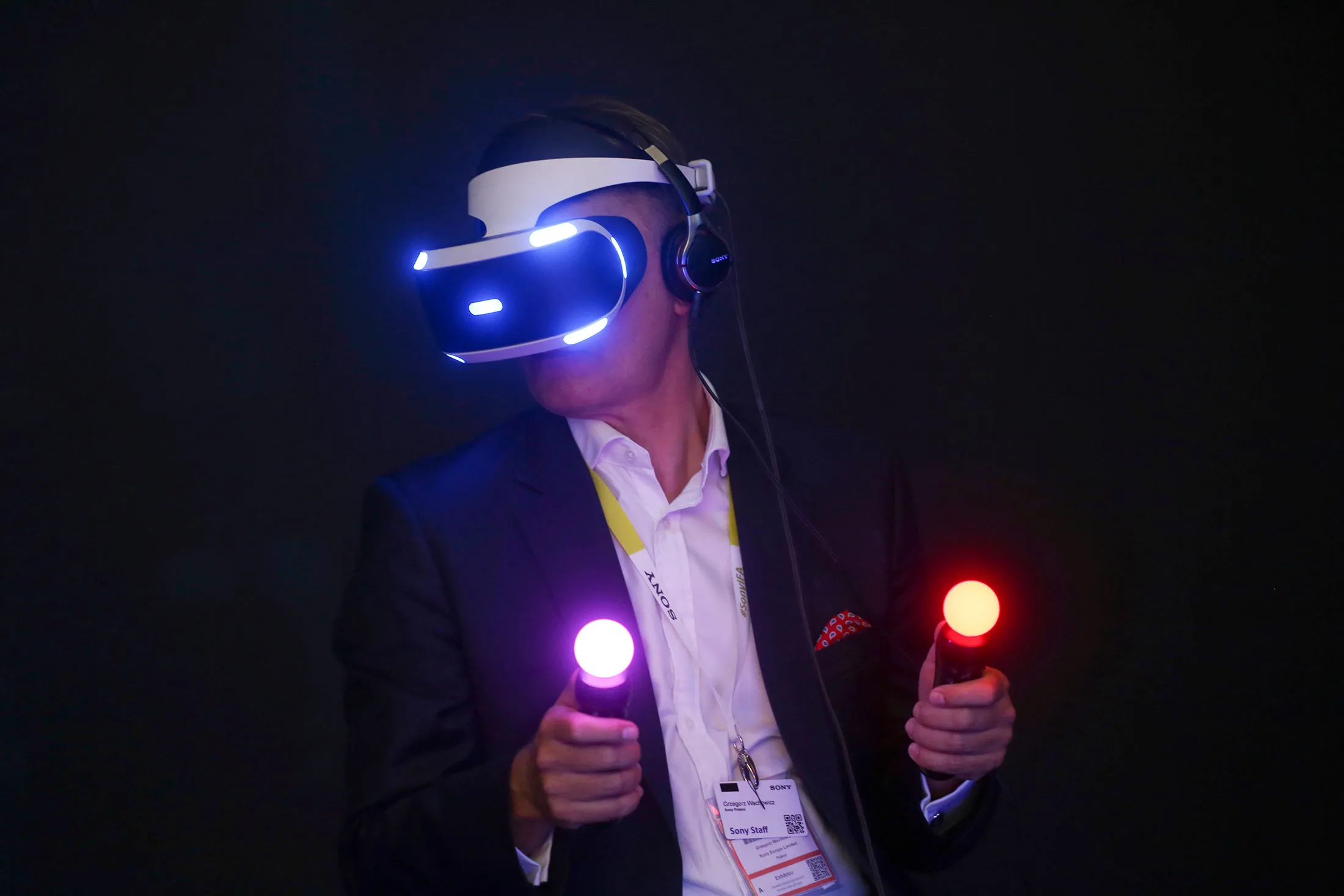 A visitor holds illuminated controllers while wearing a prototype of the Sony Project Morpheus virtual reality gaming headset at the Sony Corp. exhibition stand during previews of the IFA International Consumer Electronics Show in Berlin, Germany, on Thursday, Sept. 3, 2015.
