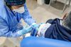 A health worker administers the Moderna Inc. Covid-19 vaccine to a visitor at a Covid-19 vaccination center in Rome, Italy, on Wednesday, March 17, 2021. Europe's biggest countries, including Germany and France, suspended use of AstraZeneca Plc's Covid-19 vaccine amid a growing health scare that's creating yet another delay for the European Union's inoculation campaign.