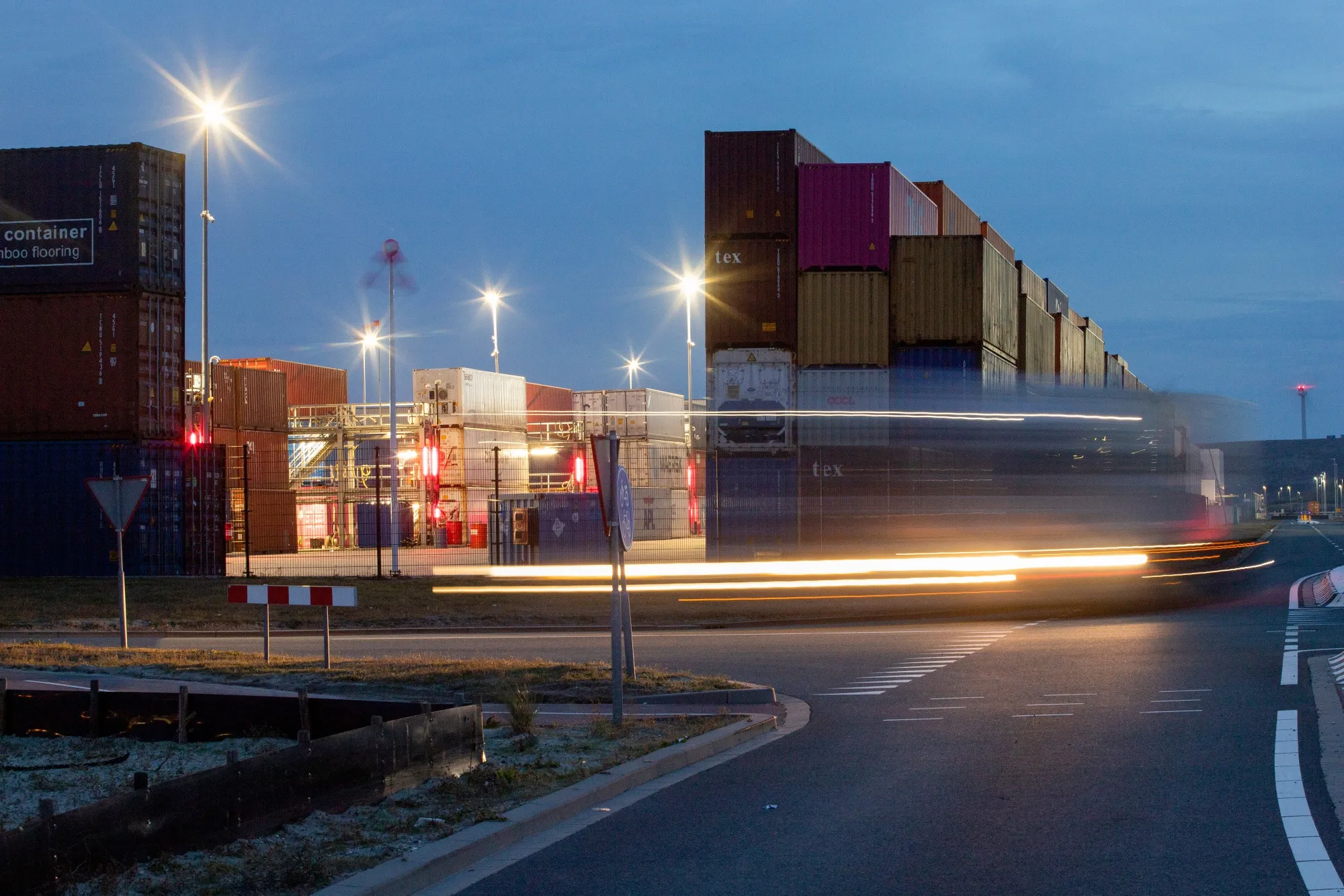 A haulage truck passes stacks of shipping containers at the Port of Rotterdam, Netherlands.