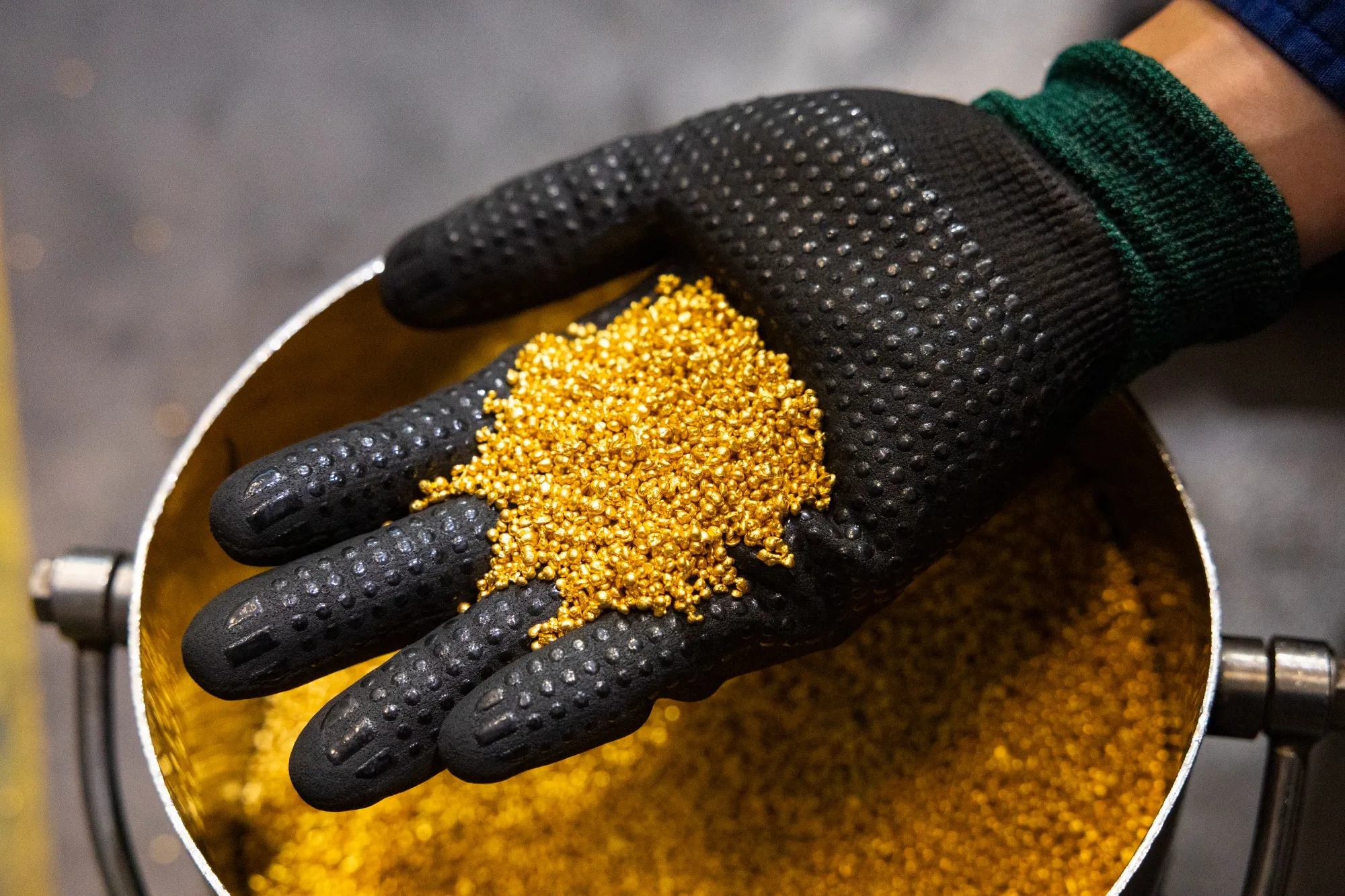 A worker holds granules of gold at the Perth Mint Refinery&nbsp;in Perth, Australia.