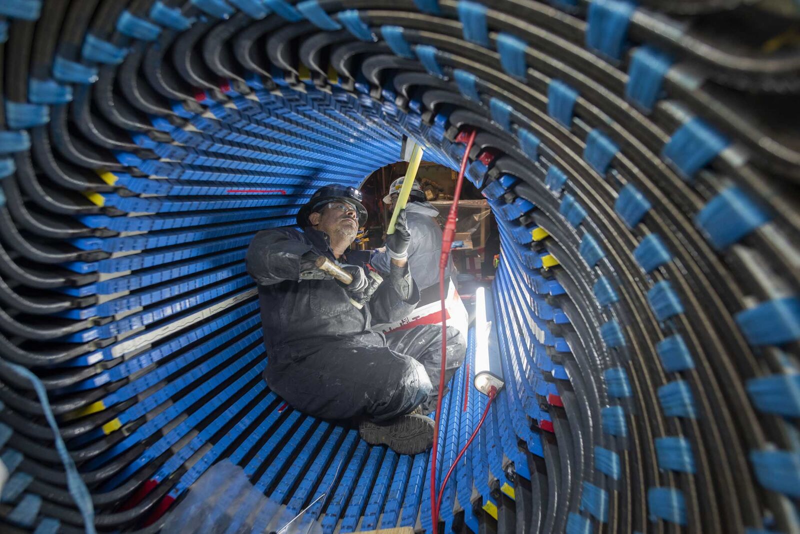 A contractor working to rewind a stator, inside a turbine that generates electricity for the Kuparuk oil field on the North Slope of Alaska.
