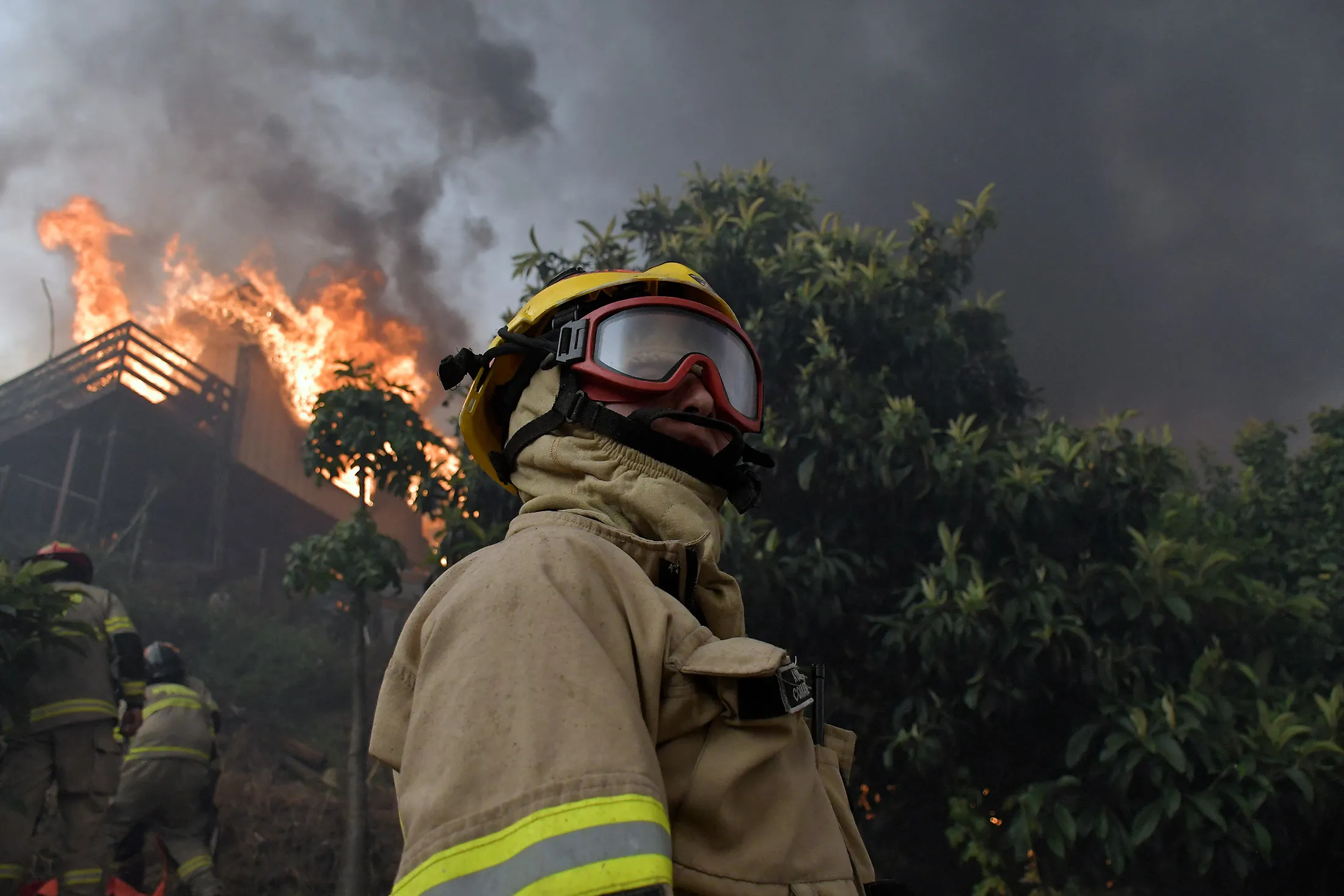 Firefighters try to extinguish a burning house during a wildfire in Chile in January.