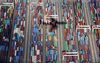 The shadow of an aircraft in flight is cast on shipping containers stacked at a terminal in Fukuoka, Japan, on Friday, April 5, 2019. Japan’s chief negotiator dodged questions about any potential auto export penalties or currency clause as he emerged from the first day of long-awaited trade talks with the U.S. in Washington, D.C., U.S., on April 15.