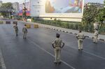 Police officers stand guard at a checkpoint on the empty Marine Drive during a lockdown imposed due to the coronavirus in Mumbai on March 25.