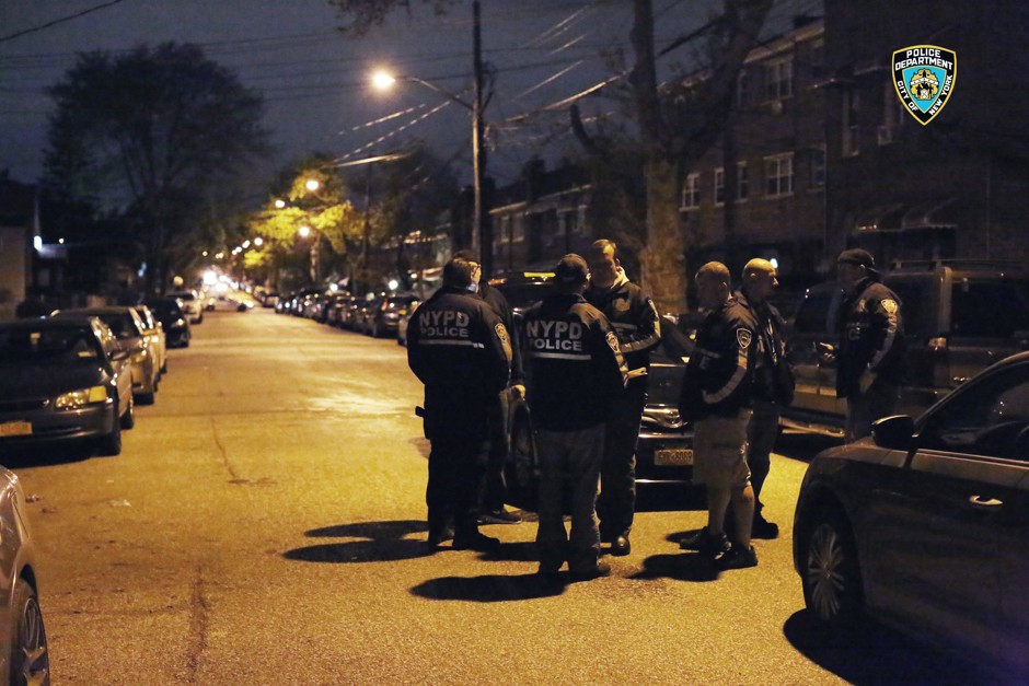 Officers gather in the Bronx during a takedown of two alleged gangs in the early hours of Wednesday, April 27, 2016. 
