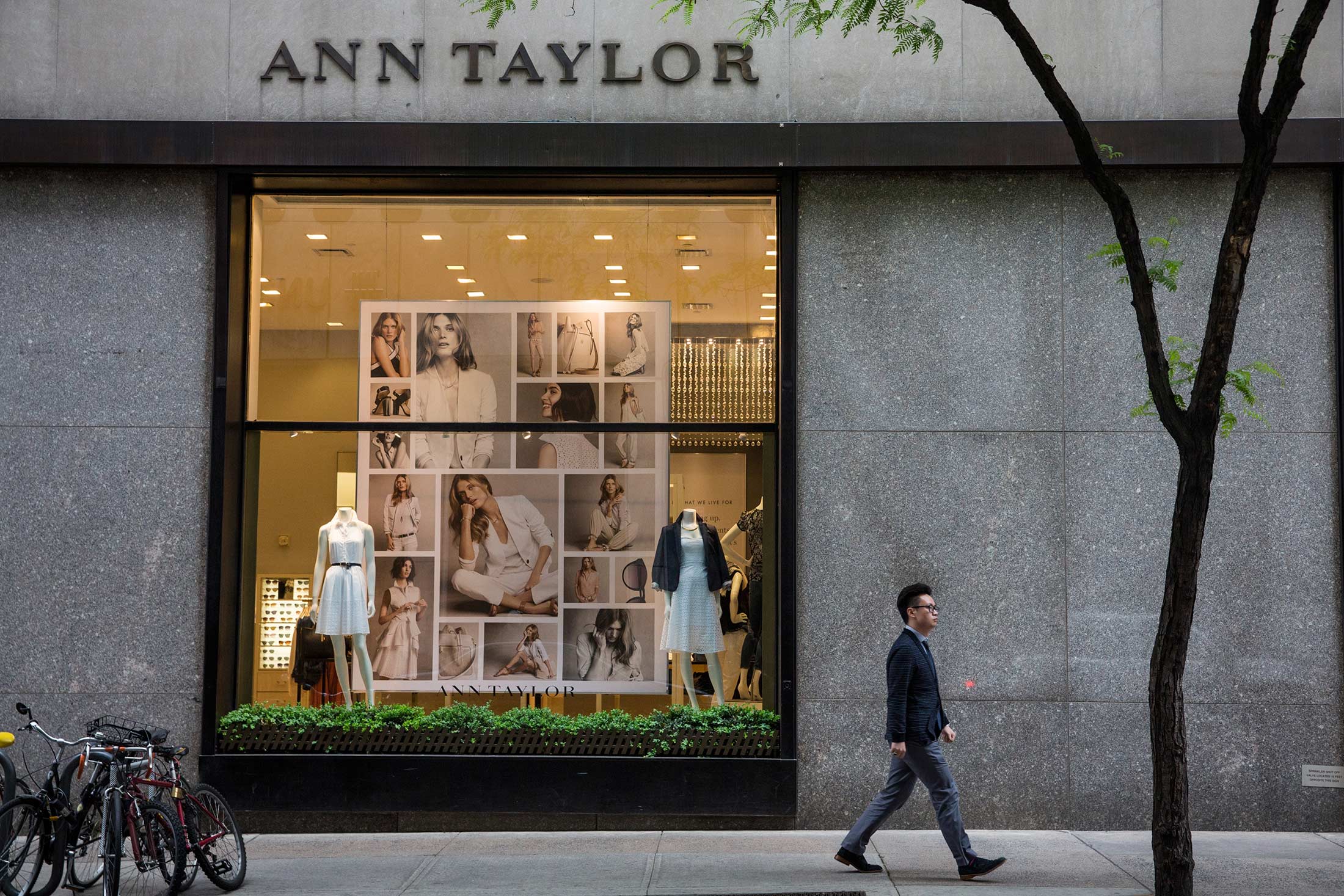 People pass the window display of an Ann Taylor women's clothing store in Manhattan.
