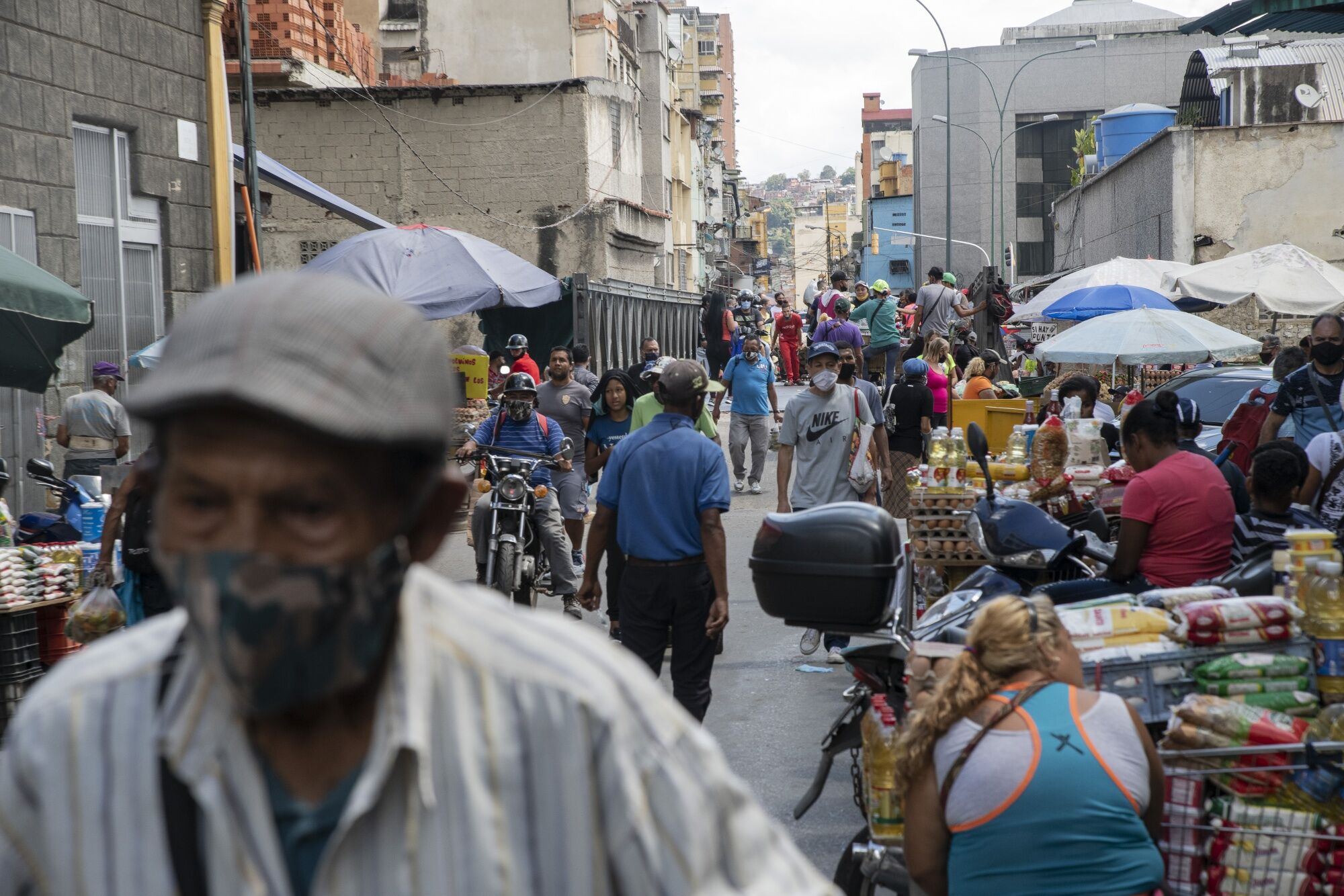 People wearing protective masks walk through Quinta Crespo Market in Caracas, Venezuela, on Feb. 4.