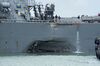 Damage to the portside is visible yeserday as the guided missile destroyer USS John S. McCain steers toward Changi Naval Base, Singapore.
