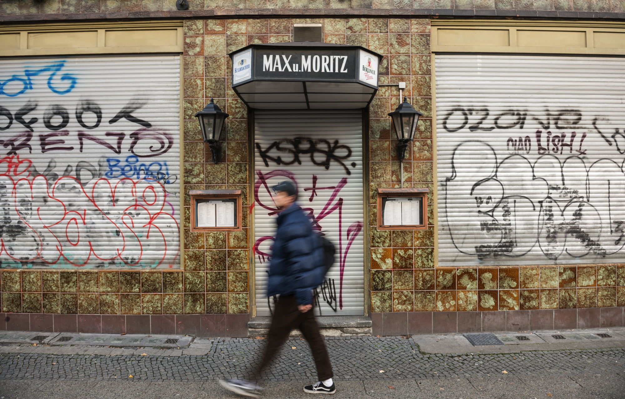 A pedestrian passes a shuttered restaurant, closed due to lockdown measures, in Berlin.
