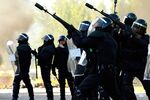 Riot police aim tear gas near a burning barricade during a miner's strike in Vega del Rey, Spain